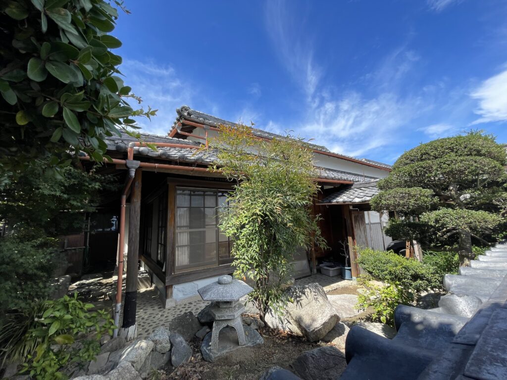 母屋の外観。庭木がよく手入れされています