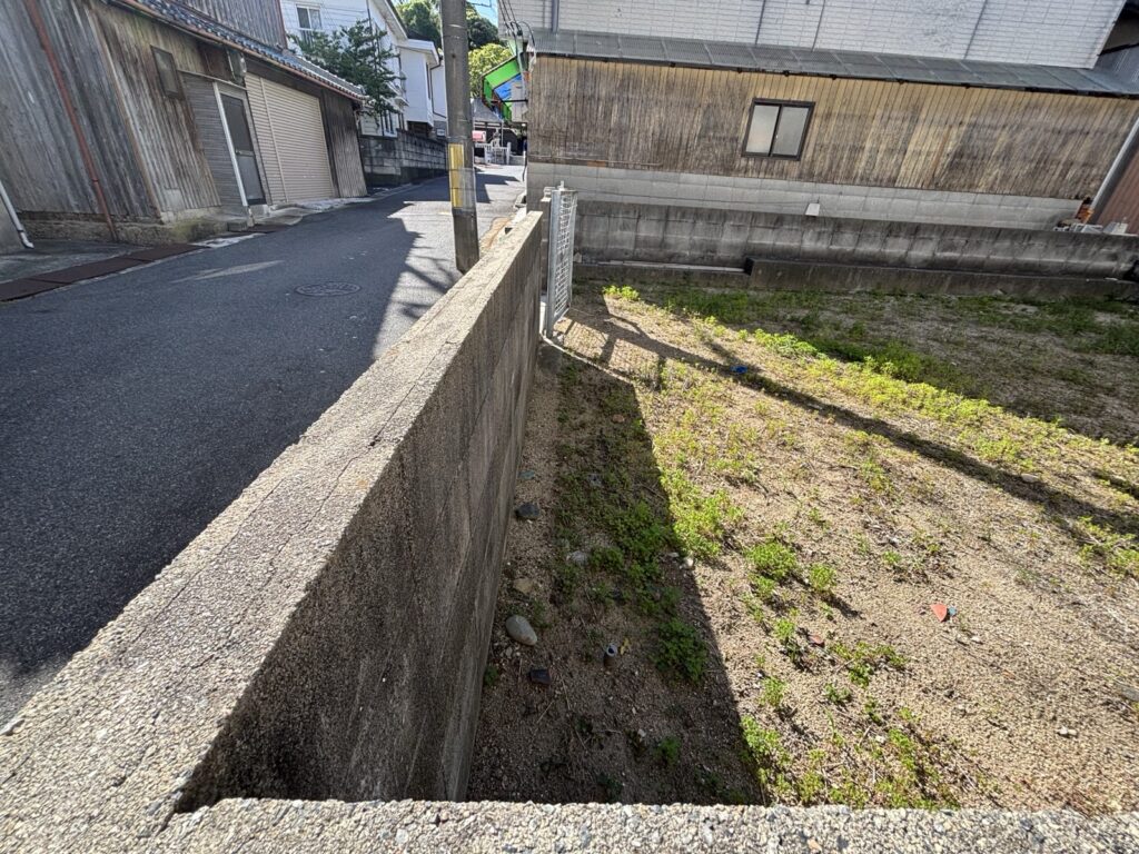 道路との境の擁壁。敷地は道路からわずかに下がります