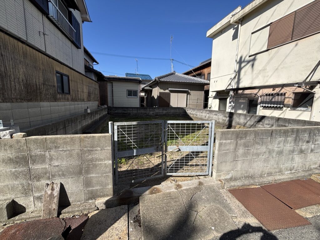 道路から見た入口。門扉が付いています