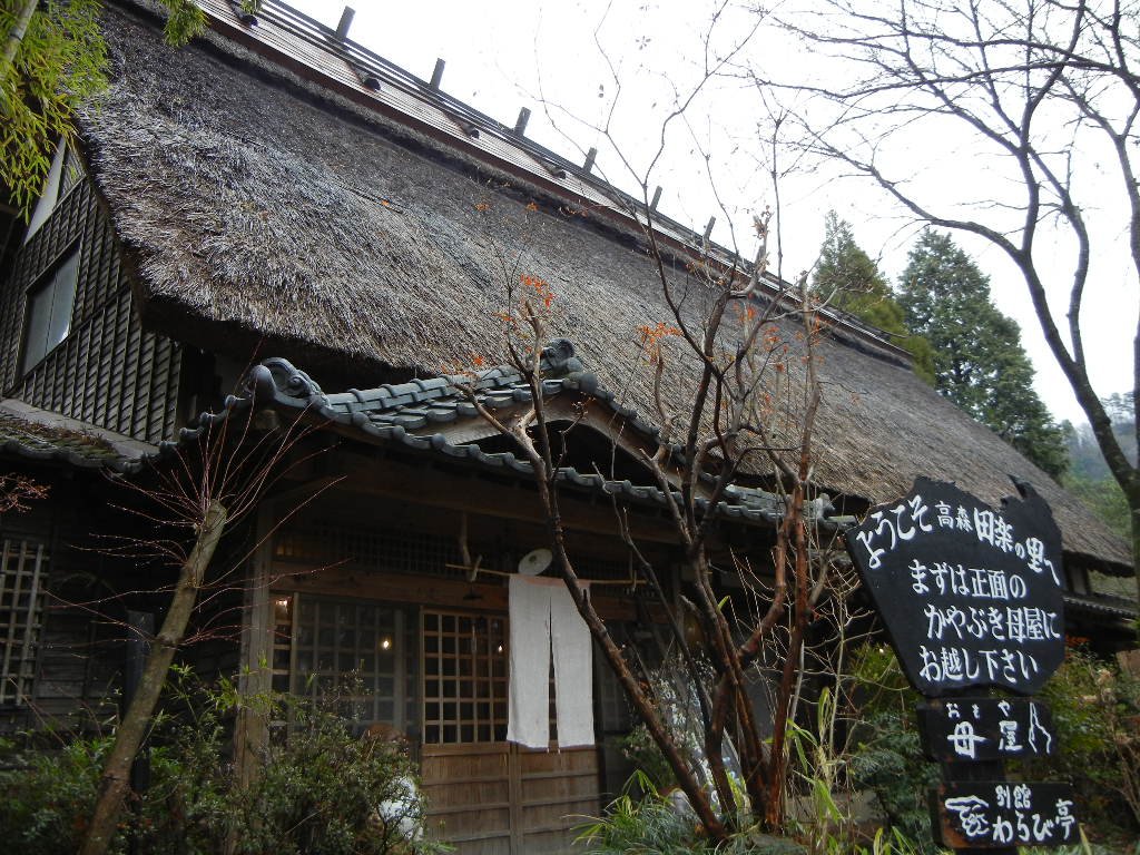 高森田楽の里。茅葺きの母屋の前に「ようこそ高森田楽の里へ」の看板